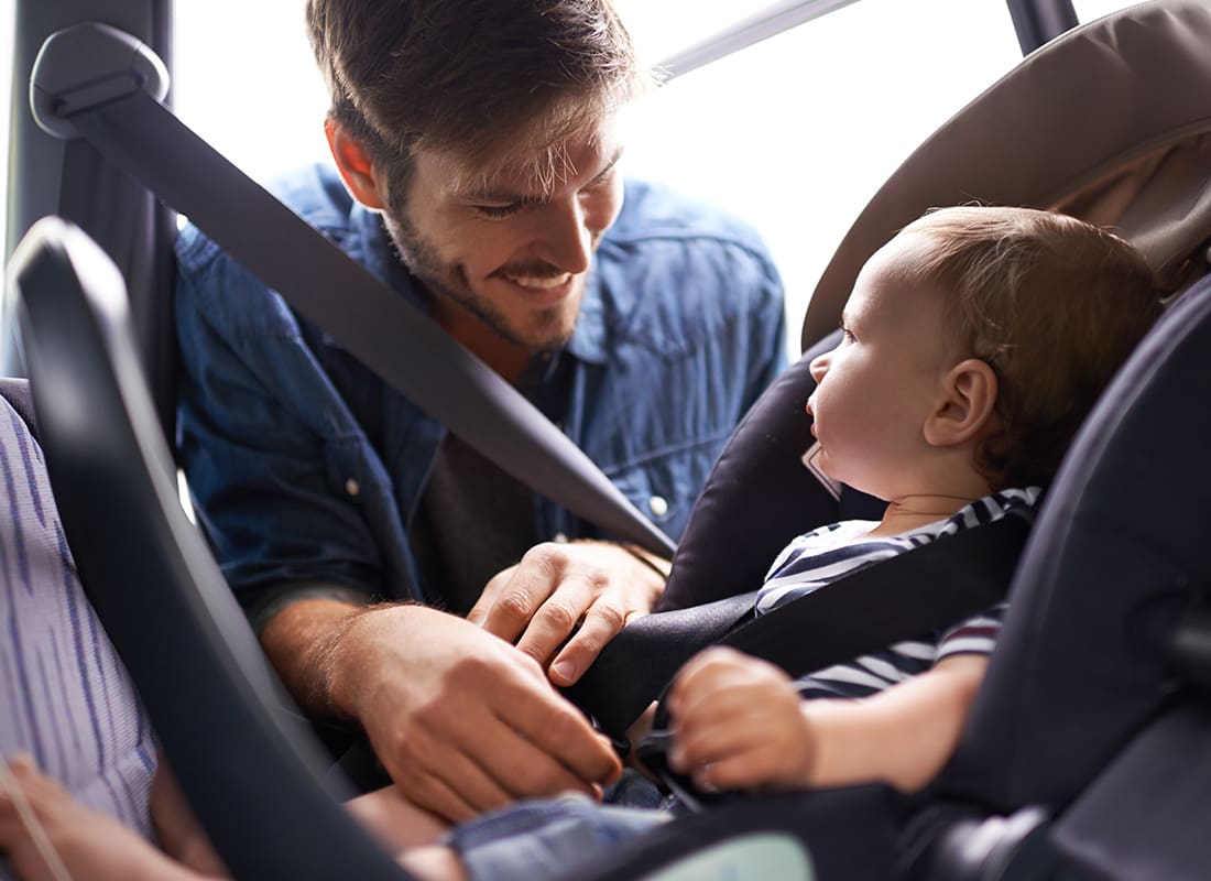 Personal Insurance - Father Putting Baby in Car Seat